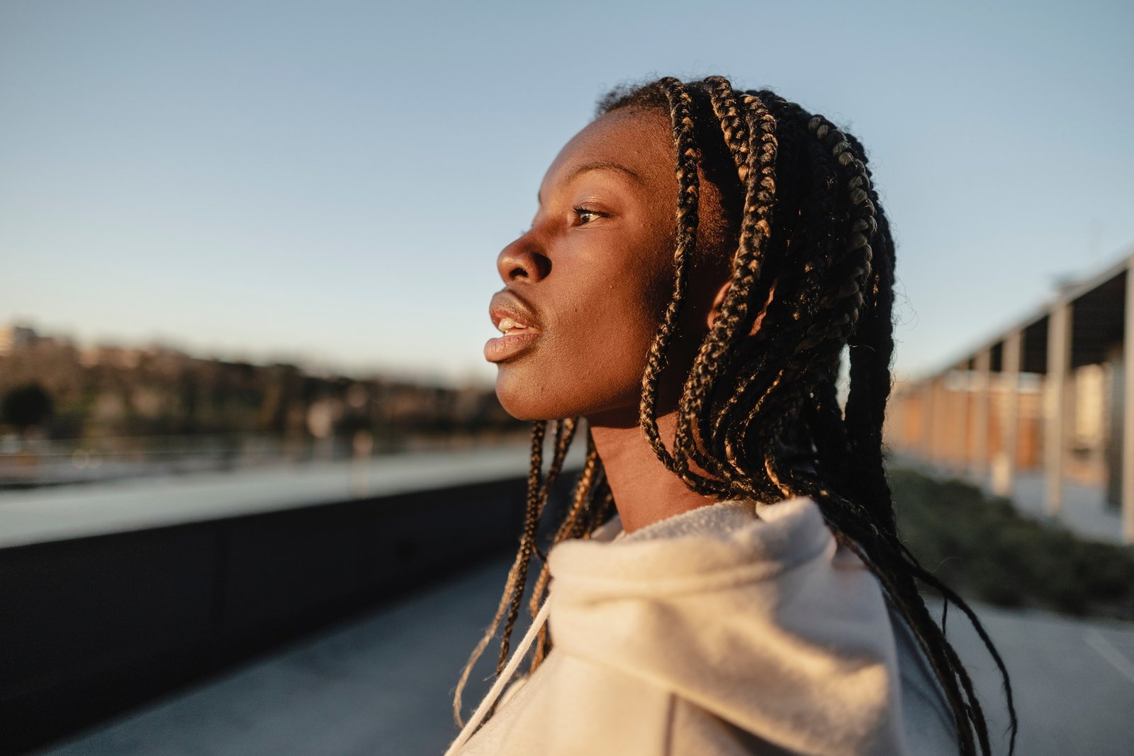 African young woman with dreadlocks, in profile contemplating the city.