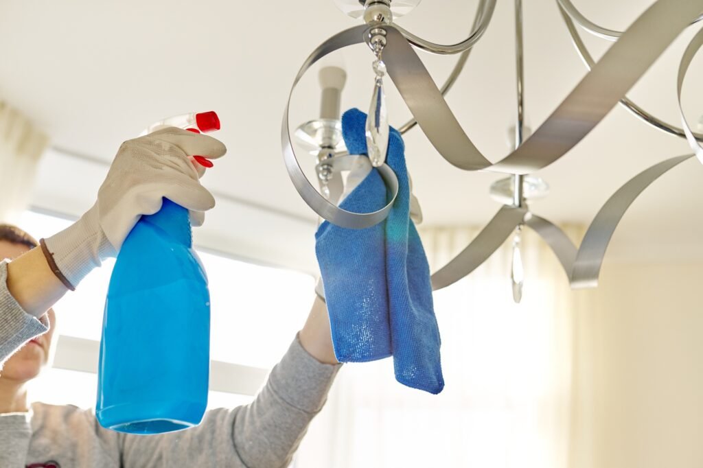 House cleaning, close-up of hands cleaning and polishing lamp