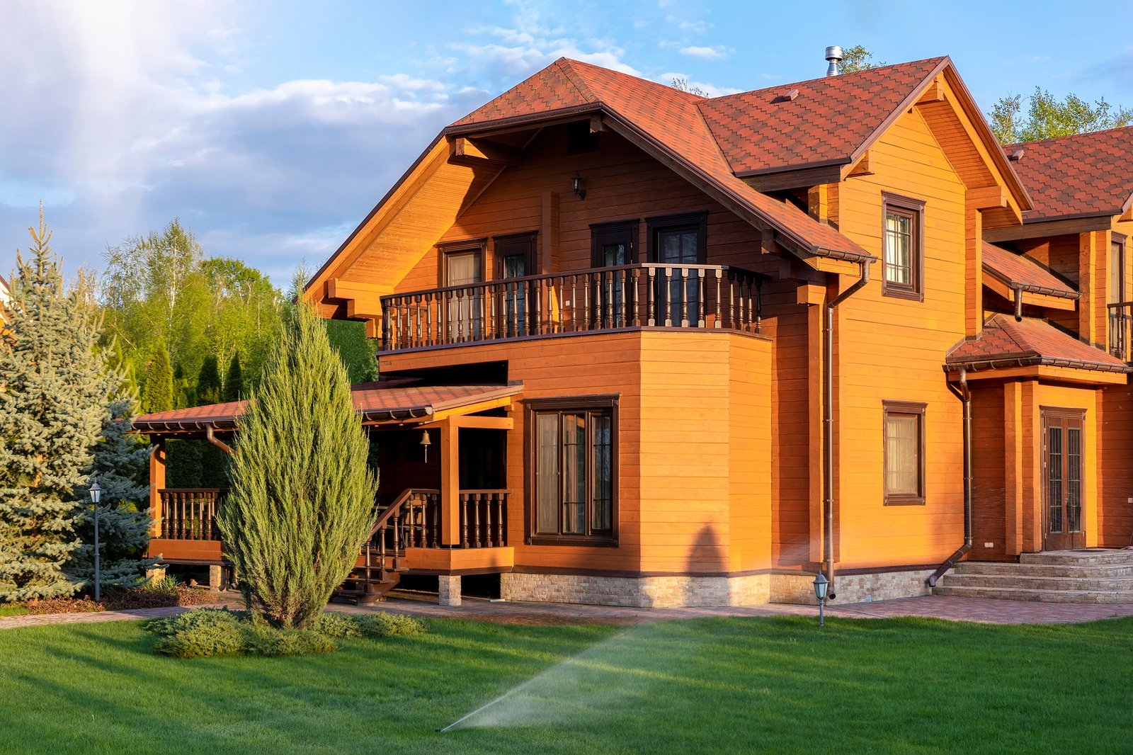 Modern wooden eco house villa facade luxury big house. Timber cottage with with green lawn water